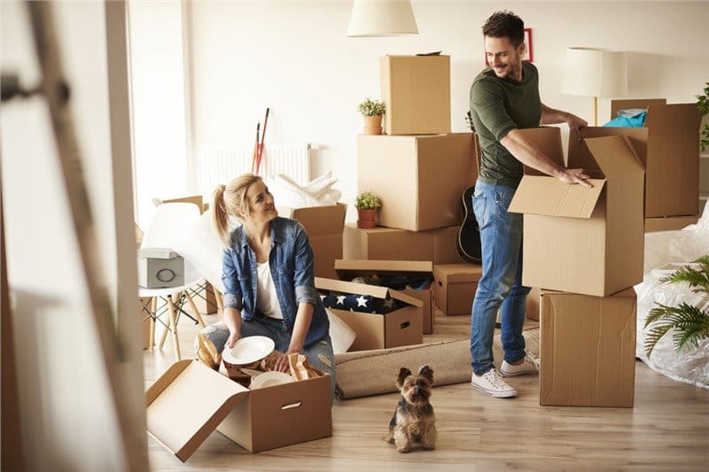 Happy couple packing boxes and preparing for a move.