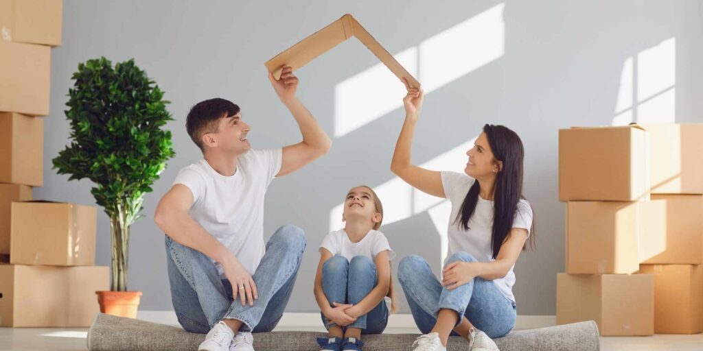 Family smiling while preparing for a move, showcasing how long it takes to prepare for a move.