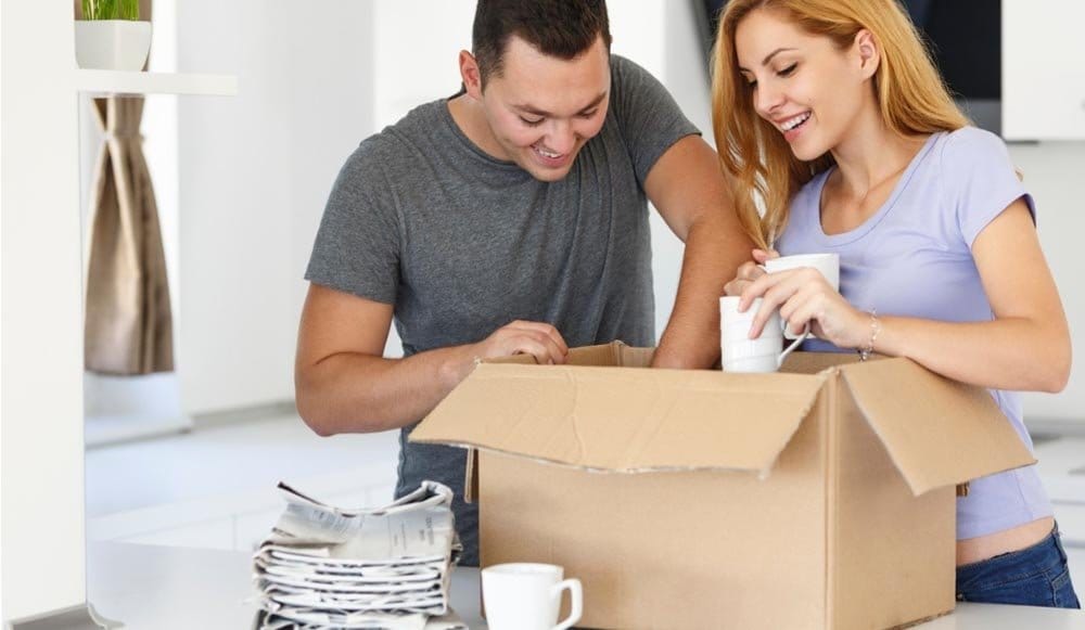 Couple packing boxes together, wondering if movers pack everything