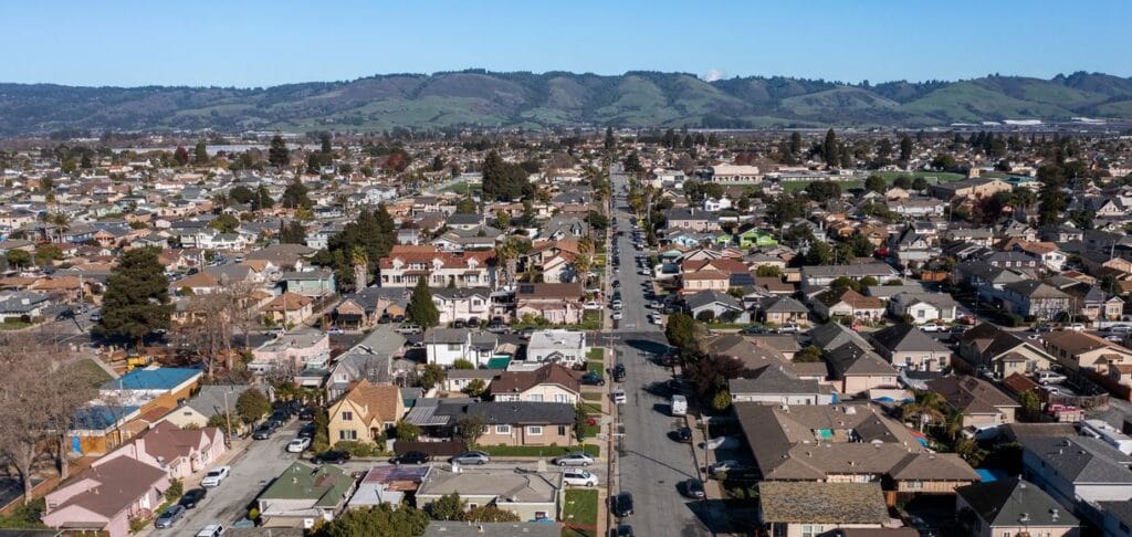 An aerial view of a residential neighborhood in Watsonville, California, with rolling hills in the background.